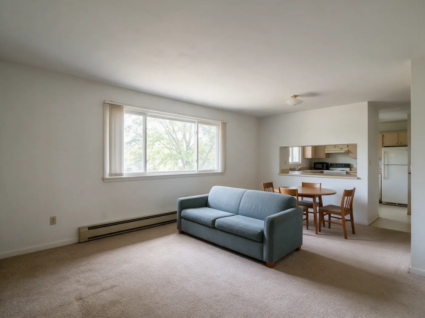 Representative photo of an apartment living and dining area with a wide window